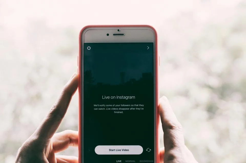 Mãos segurando um celular com o aplicativo do Instagram aberto