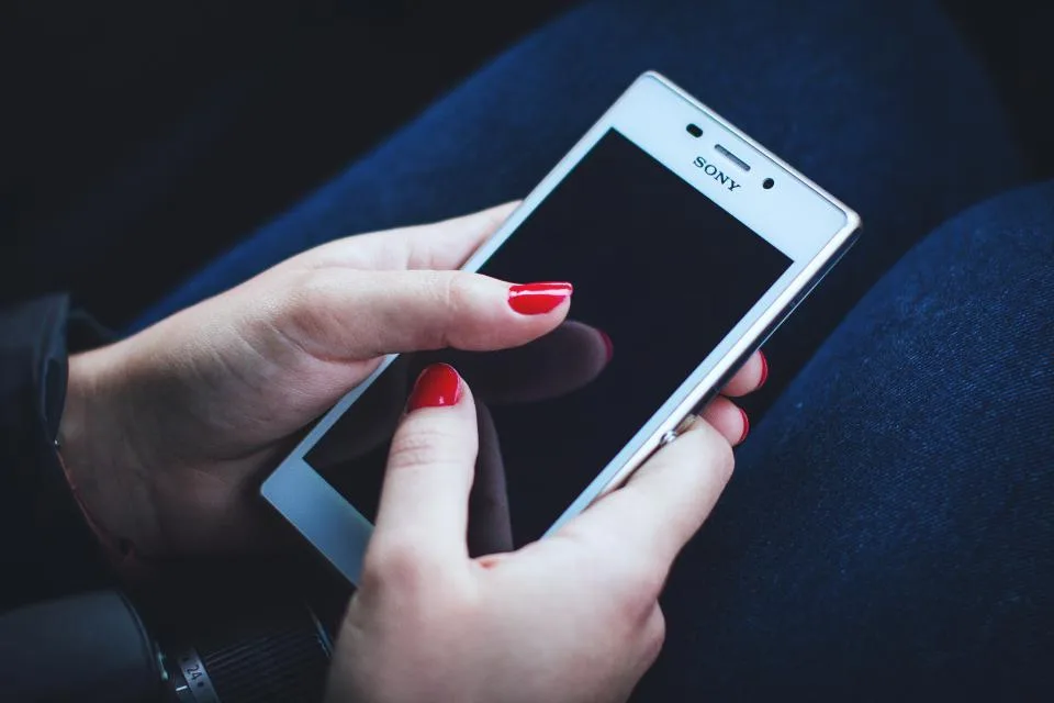Mão segurando smartphone com a tela acesa