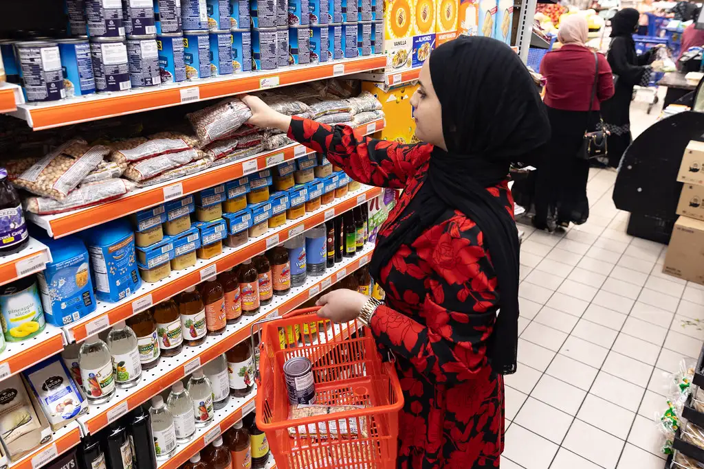 Consumidora escolhendo produtos na prateleira de um supermercado