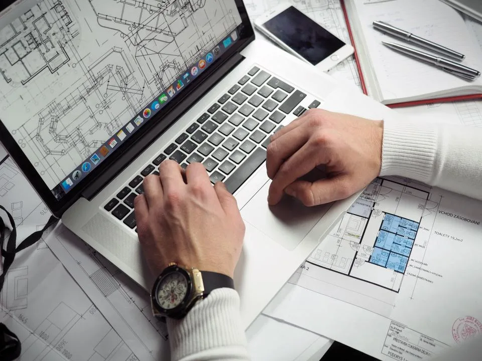 Designer trabalhando no notebook com mesa digitalizadora