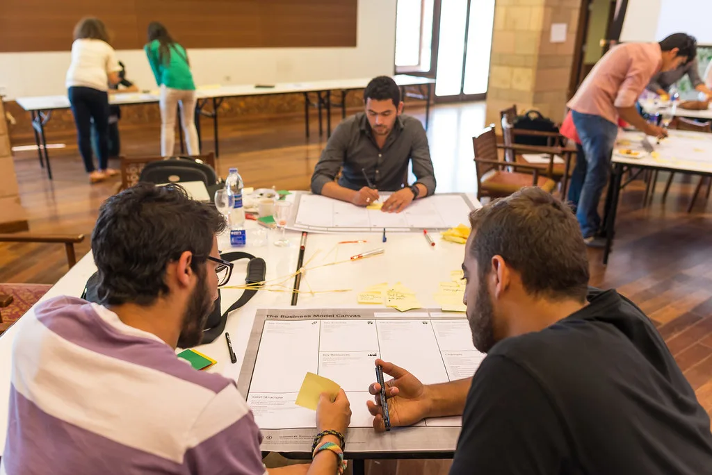 Equipe reunida em volta de uma mesa de trabalho