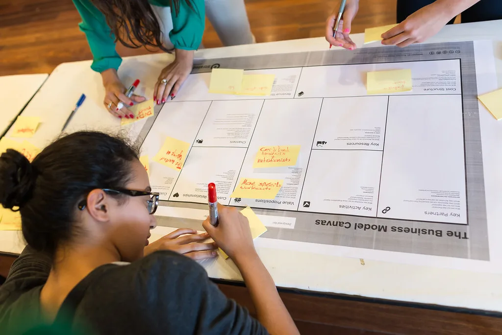 Equipe de startup trabalhando em quadro branco durante uma sessão de mentoria