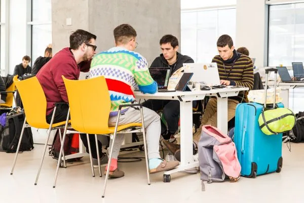 Equipes trabalhando em notebooks durante um hackathon