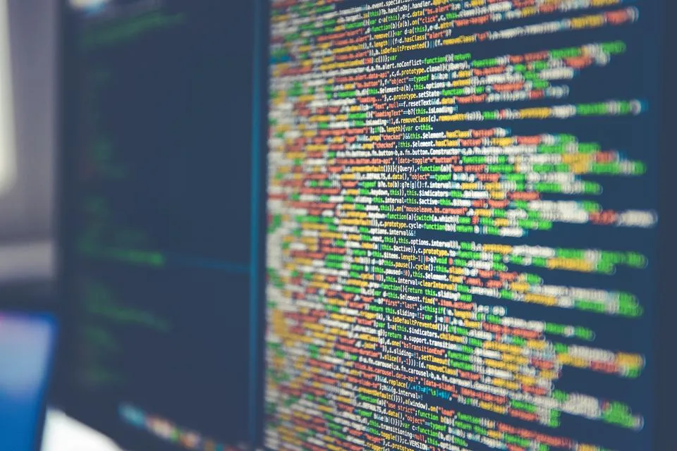 Tela de computador cheia de linhas de código coloridas