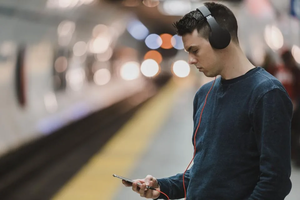 Homem com fones de ouvido olhando o celular
